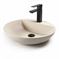 Ceramic vessel sink in cream color with black faucet for bathroom use